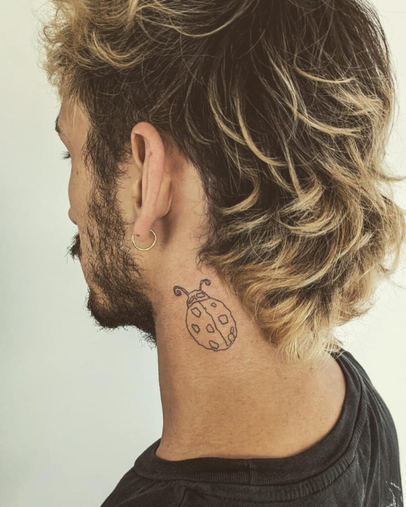 Minimalist ink outline ladybug tattoo behind the ear for men
