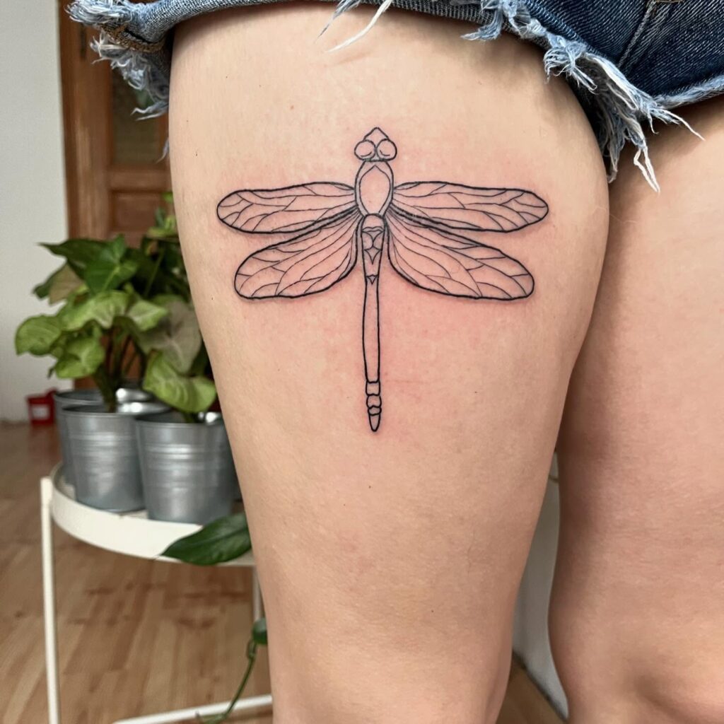 Minimalist Line-Art Dragonfly Thigh Tattoo with Geometric Elegance