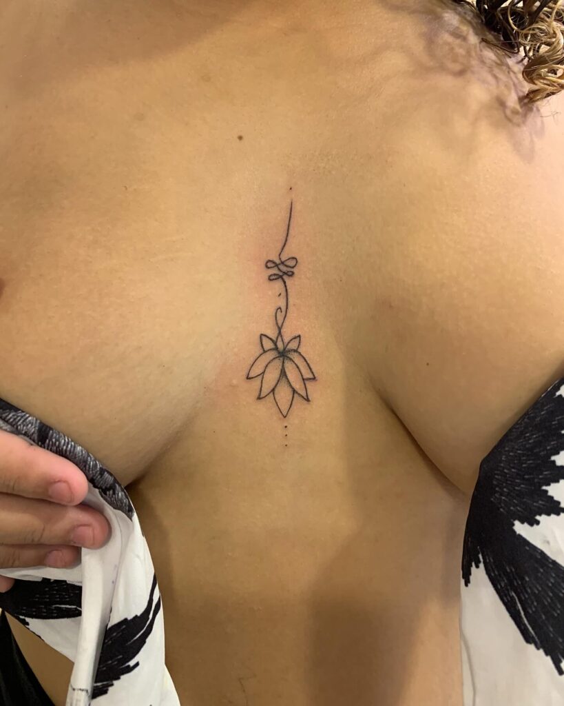 Minimalist lotus flower sternum tattoo with spiritual symbolism