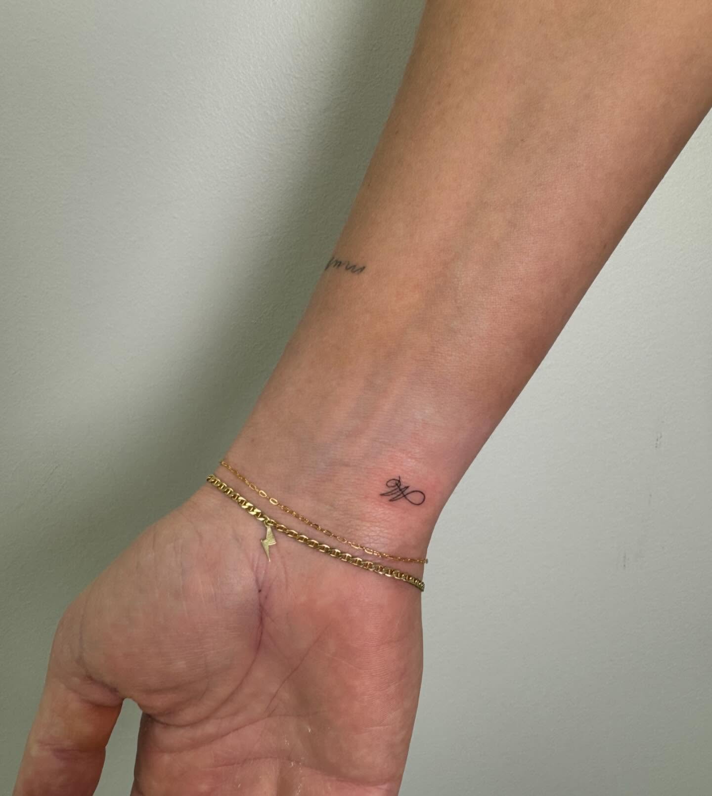 Minimalist Micro Tattoo of Letter 'M' with Infinity Flourish Elegant & Personal