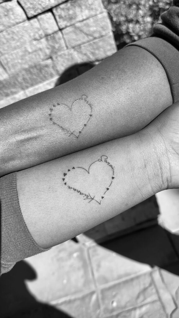Minimalist mother-daughter heart tattoo with fine-line design