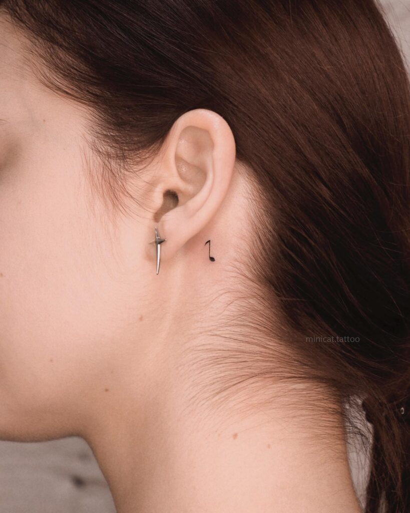 Minimalist music note tattoo behind the ear harmony in notes