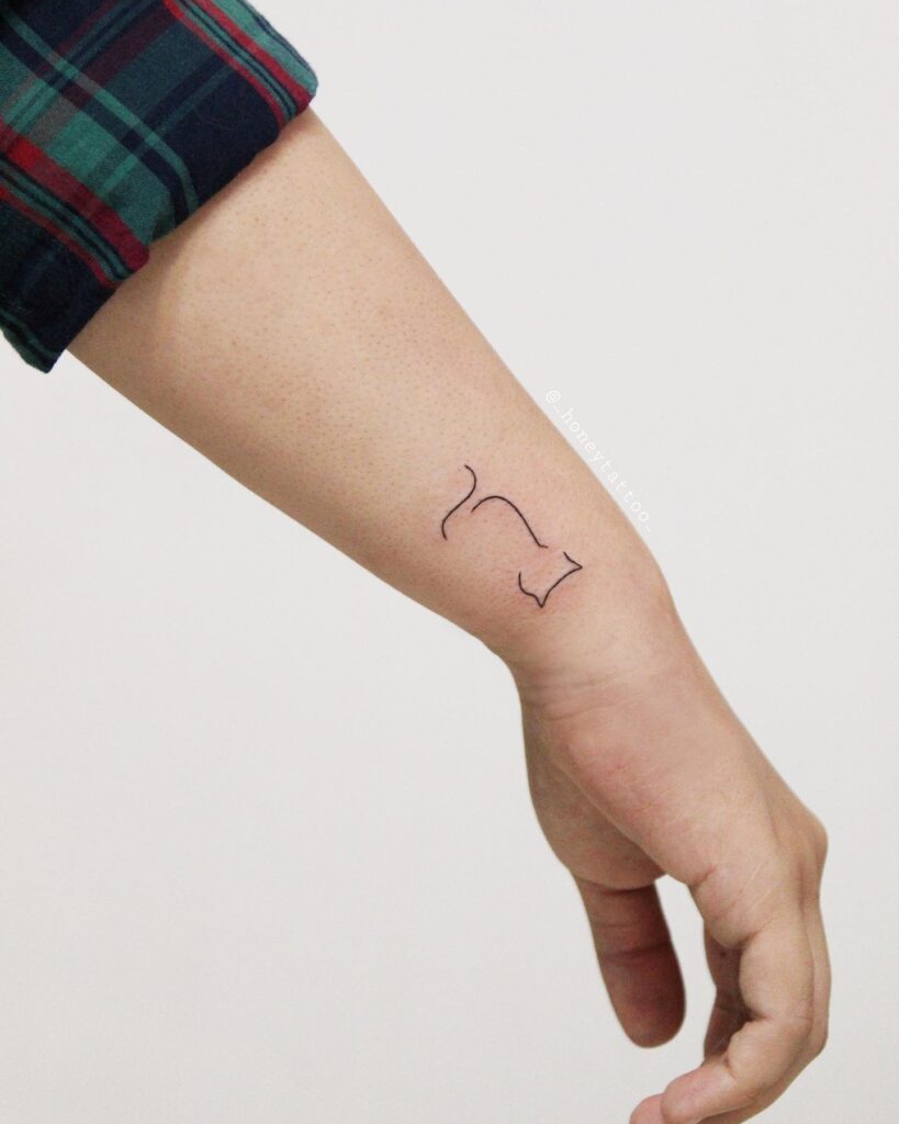 Minimalist stretching cat wrist tattoo for subtle feline lovers