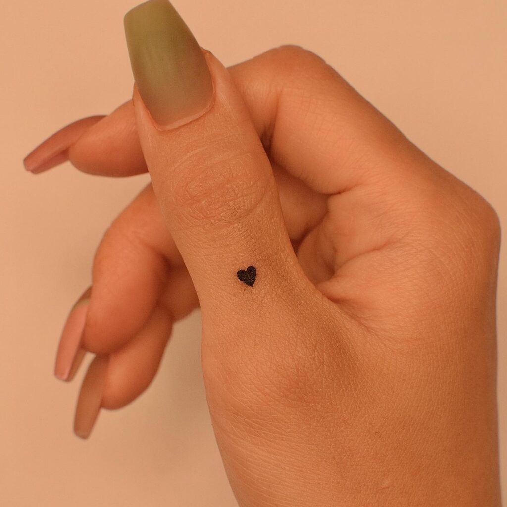 Minimalist thumb charm black heart filled love tattoo