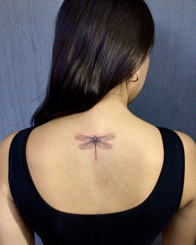 Minimalist Upper Back Dragonfly Tattoo Symbolizing Transformation and Freedom