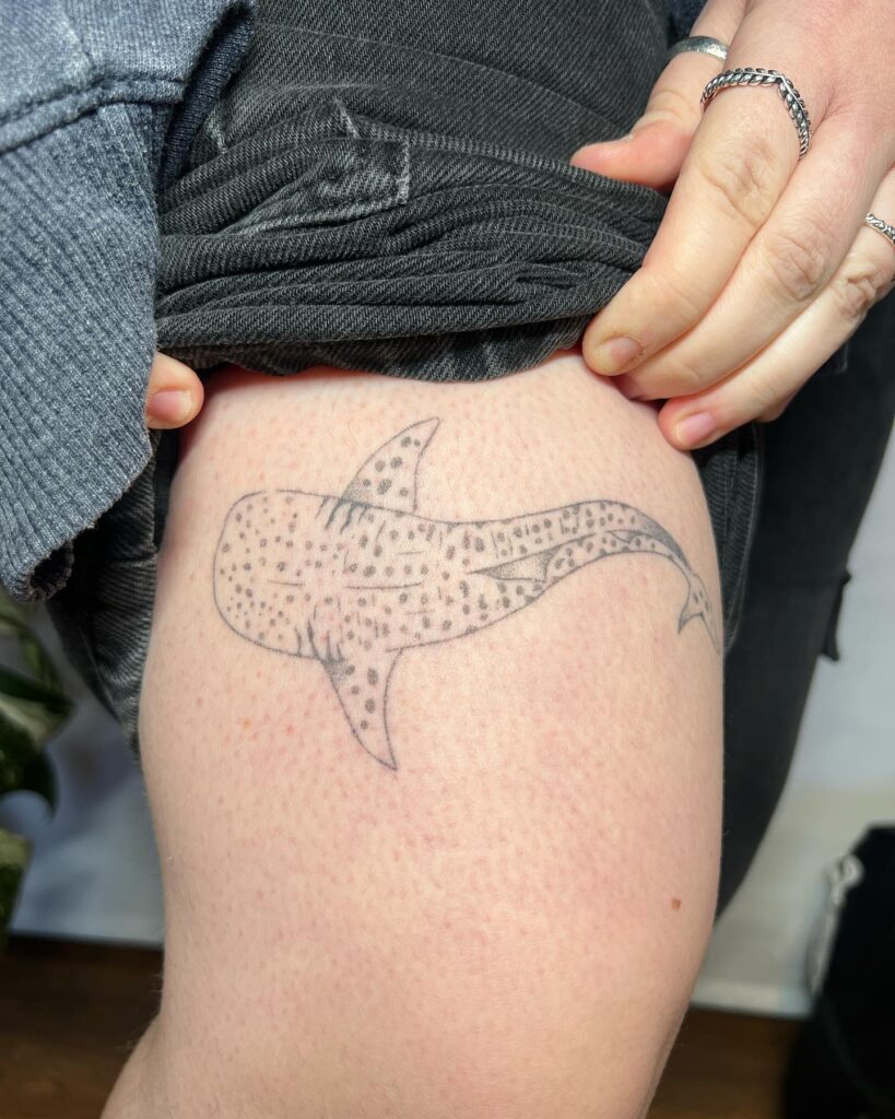 Minimalist whale shark outline tattoo on thigh with hand-drawn aesthetics