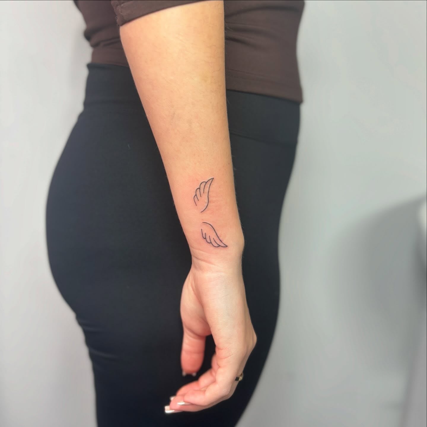 Minimalist Wings Forearm Tattoo Symbolizing Freedom and Remembrance