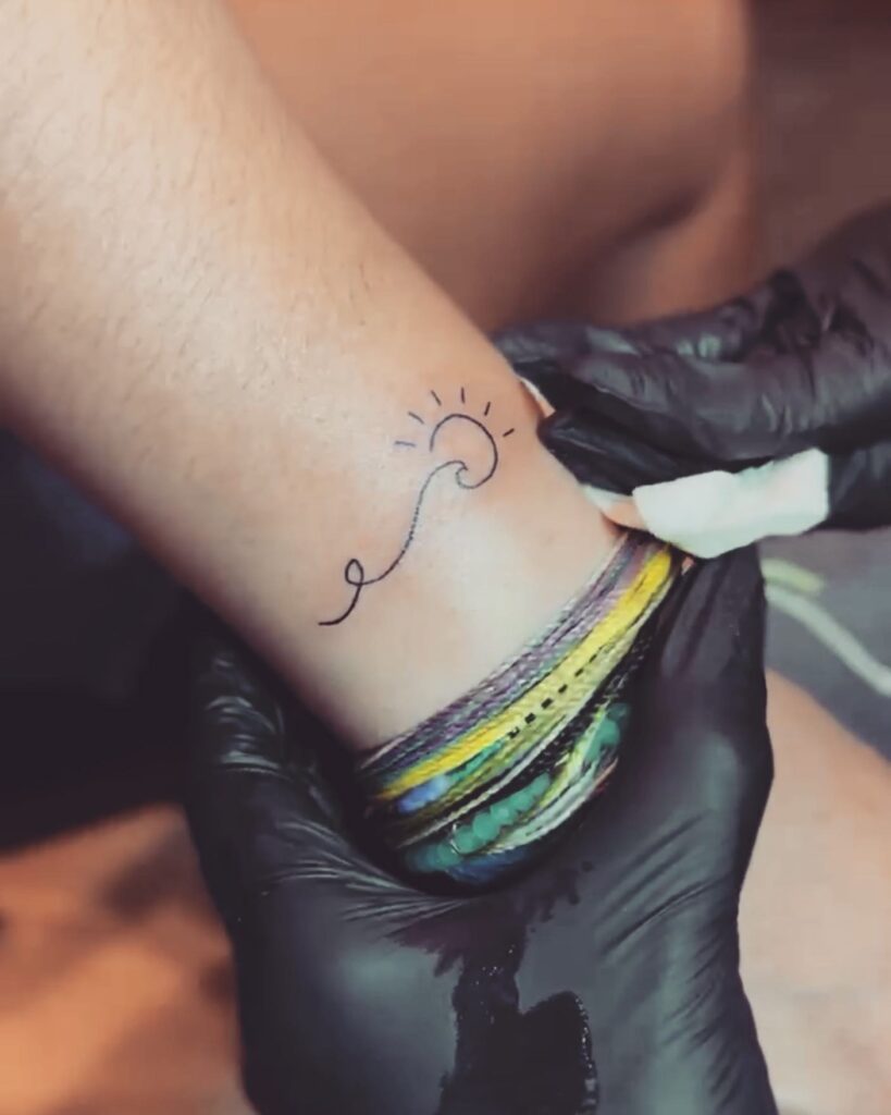 Minimalist wrist sun and wave tattoo delicate art