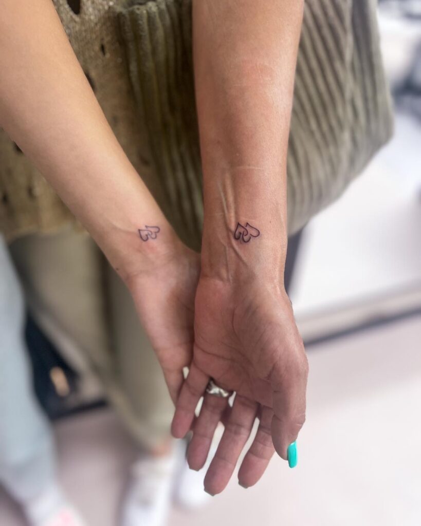 Minimalistic double-heart wrist tattoo symbolizing a lifelong mother-daughter bond