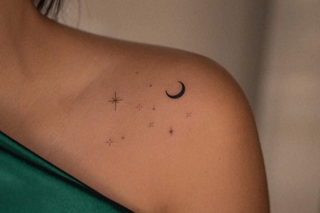 Moon and stars tattoo on female shoulder