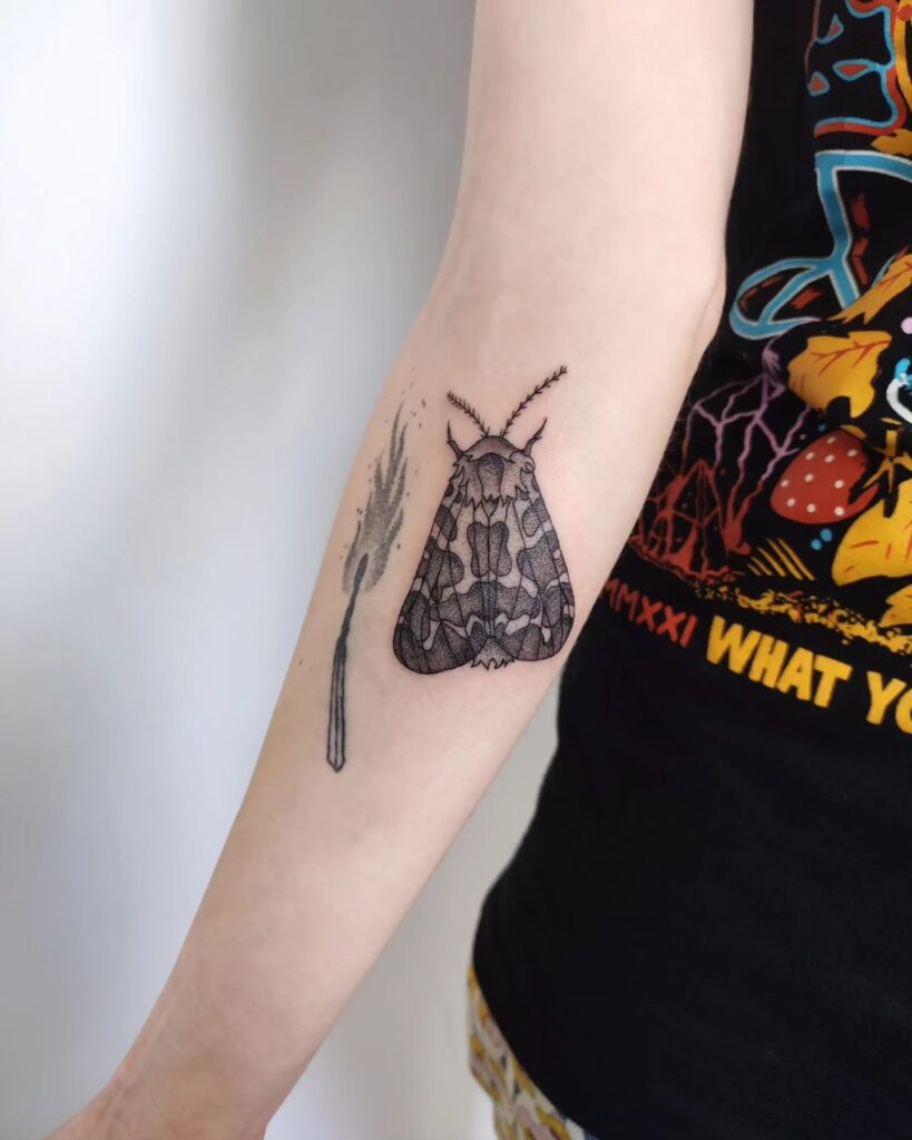 Moth to a flame forearm tattoo with a fiery twist
