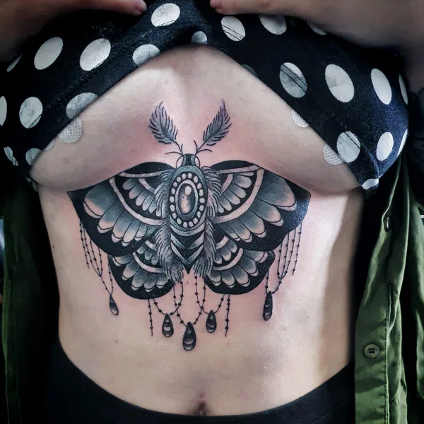 Moth under breast tattoo