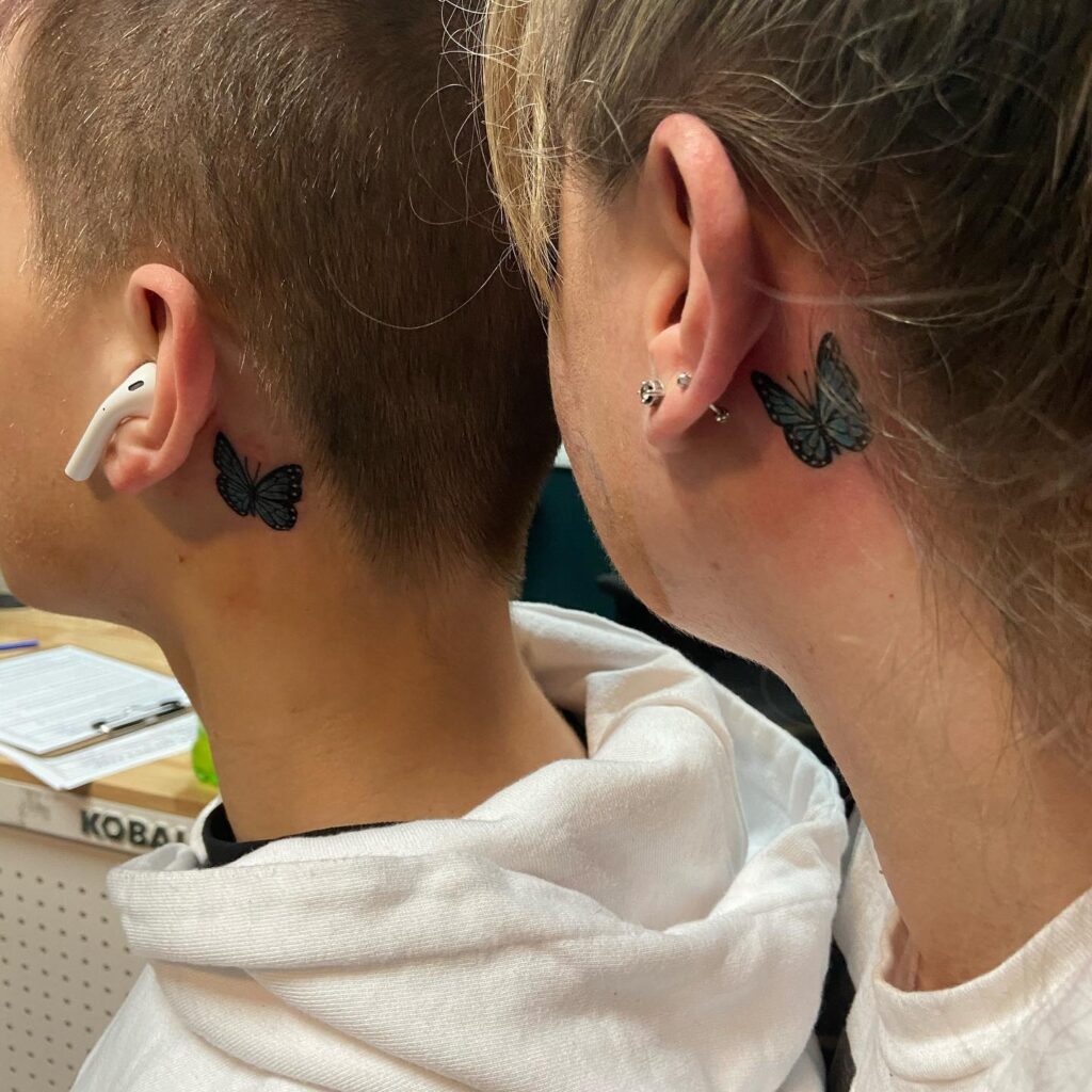 Mother son bond matching blue butterfly tattoos behind the ear
