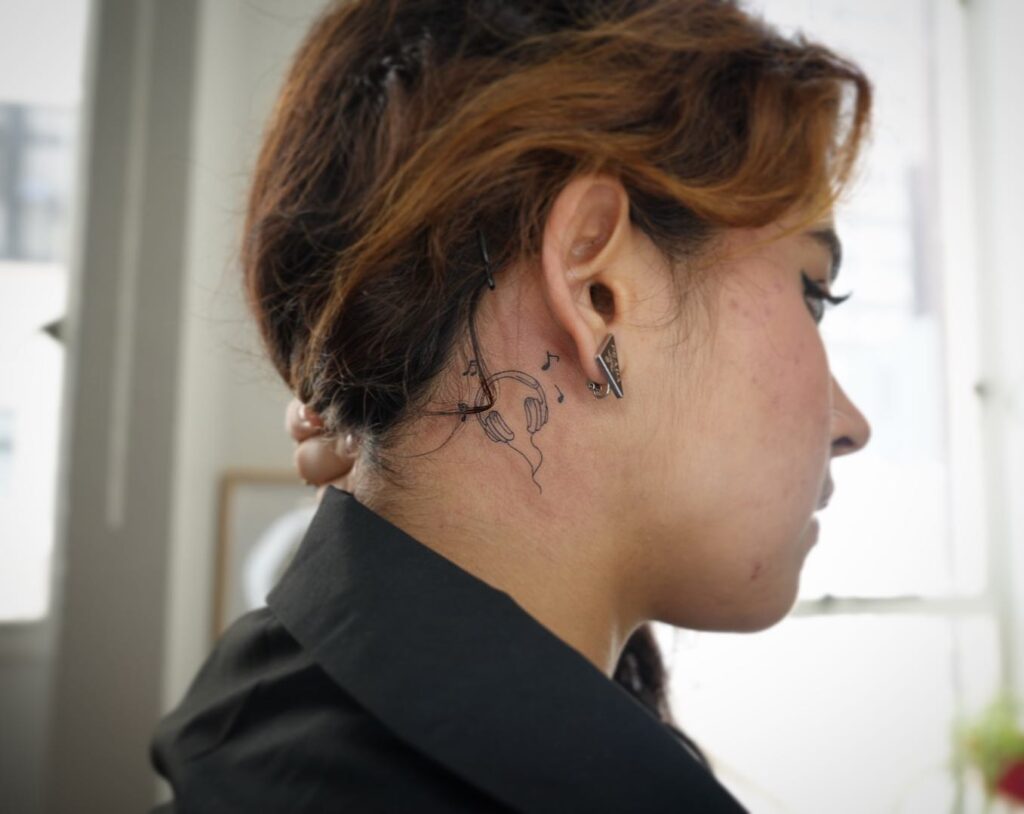 Musical muse headphones tattoo artistry behind the ear