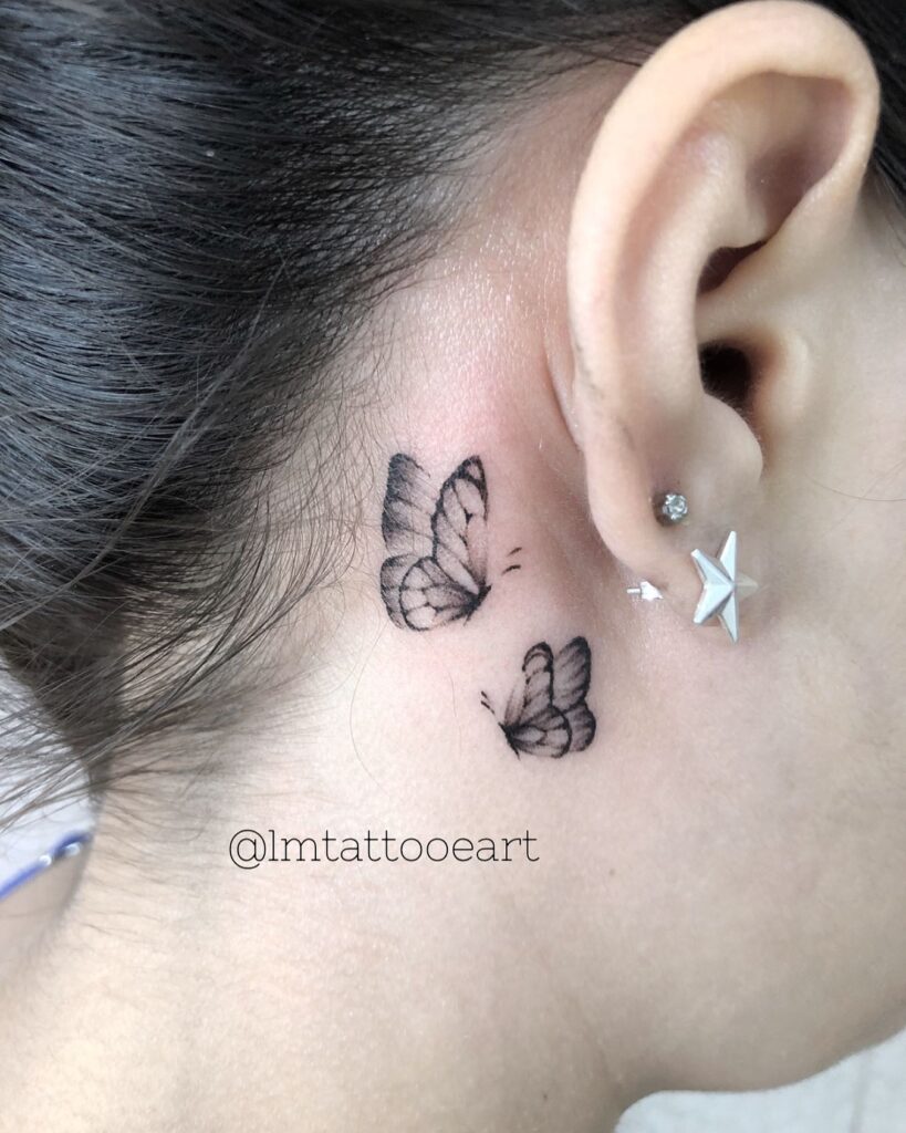Mysterious pair in black ink two small butterflies for feminine tattooing on the side of the neck