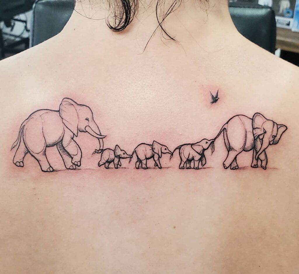 Nature-inspired elephant family tattoo on the back: matriarchal majesty