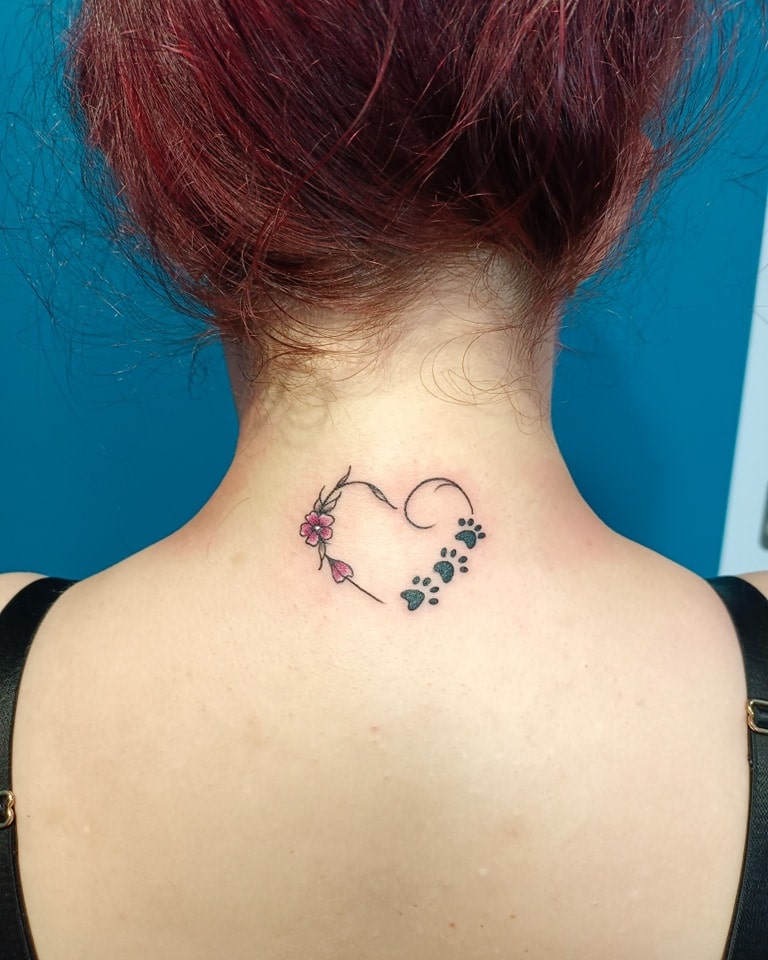 Nature's embrace flower and paw print outline heart tattoo on the forearm