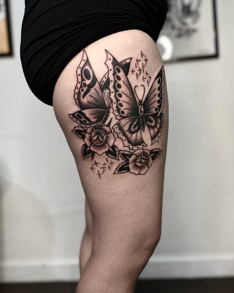 Natures harmony butterfly sitting on rose tattoo on thigh for females