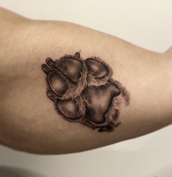 Neat and detailed realism dog paw print on the upper inner arm
