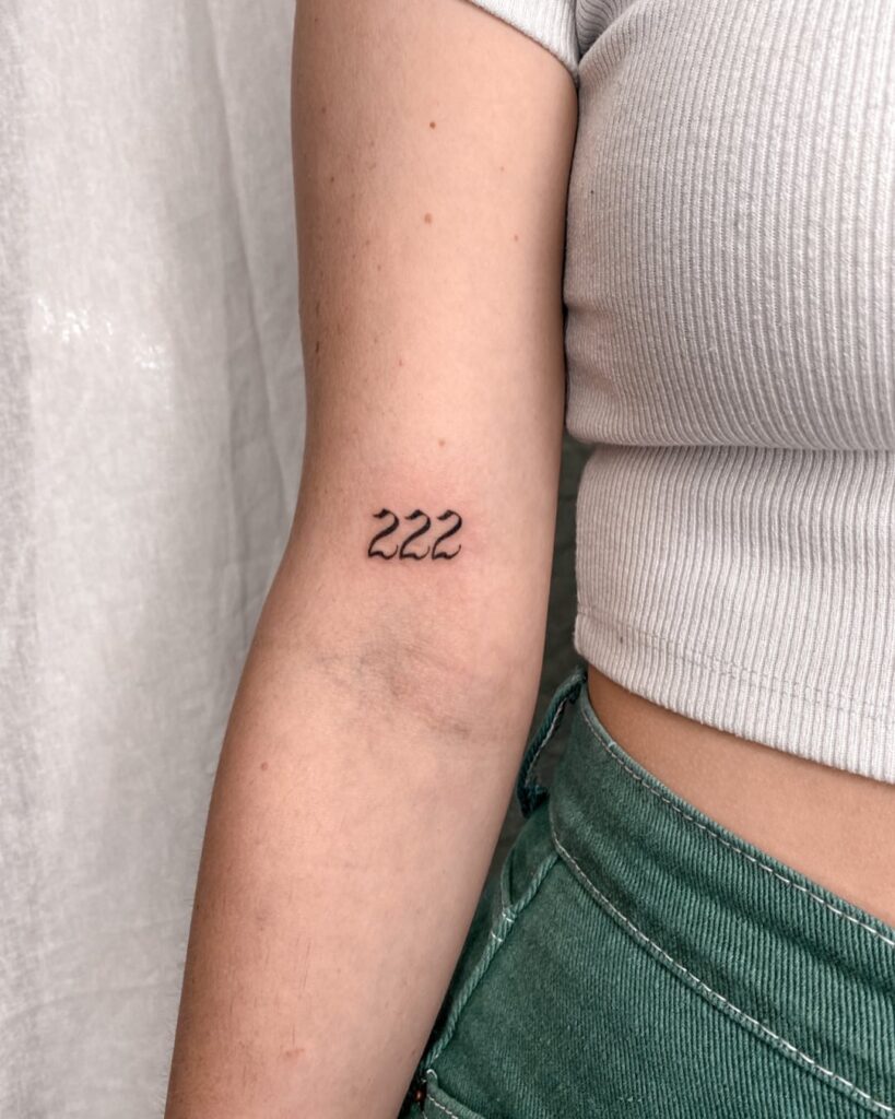 Numerical charm 222 number tattoo above the elbow