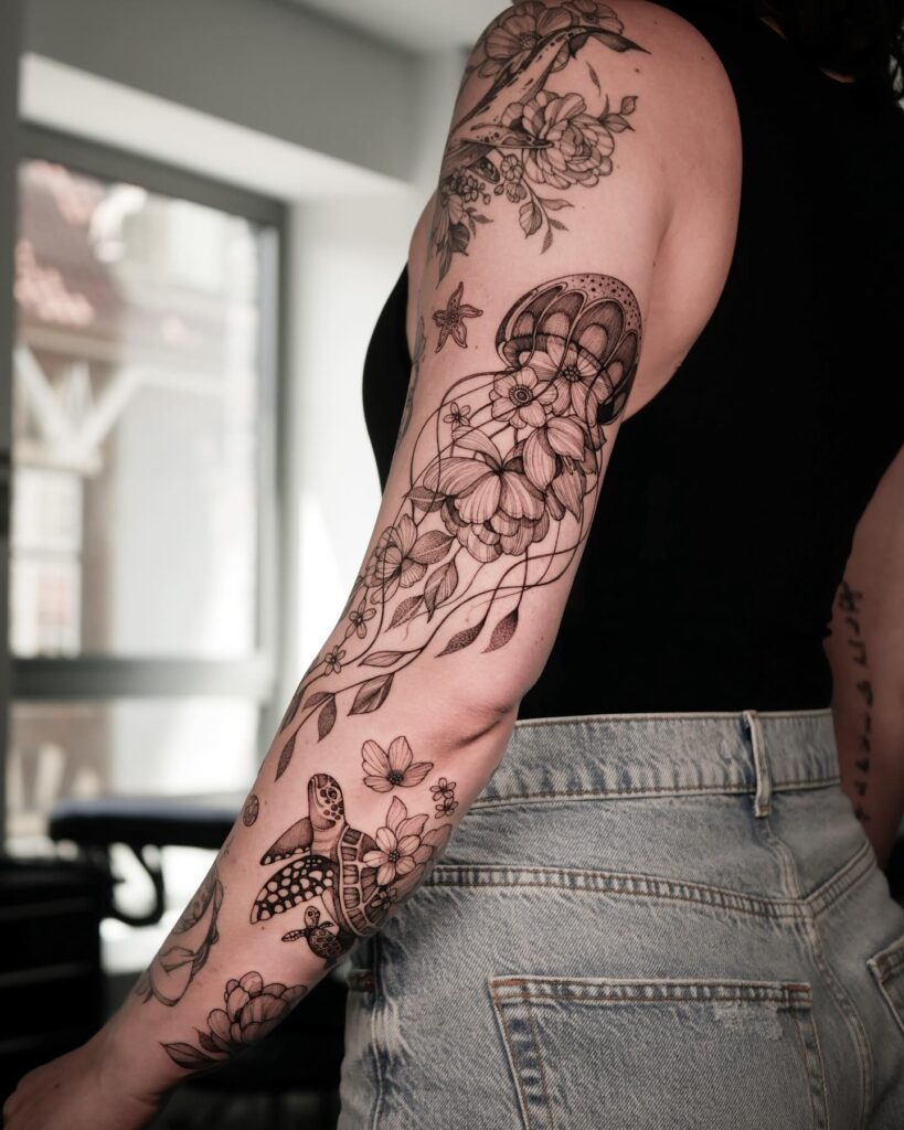 Ocean-inspired tattoo sleeve with sea turtles, starfish, and flowing floral patterns