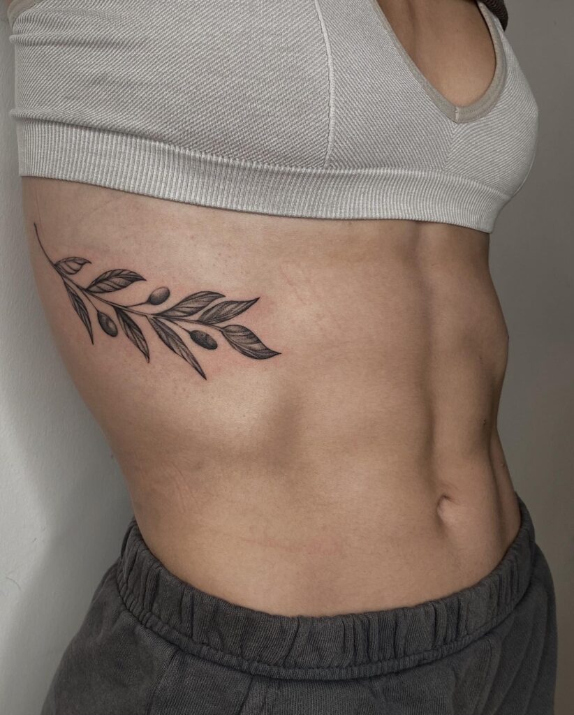Olive branches tattoo enhancing the grace of the side rib-olive branch elegance