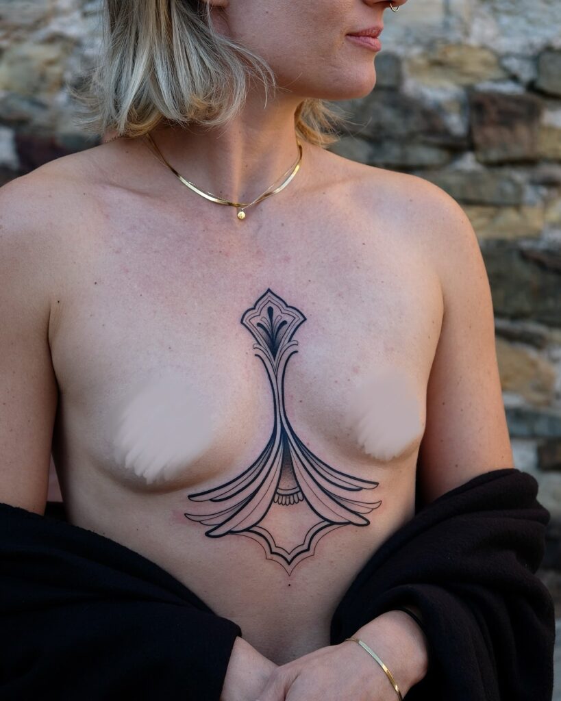 Ornamental Art Nouveau sternum tattoo with symmetrical elegance