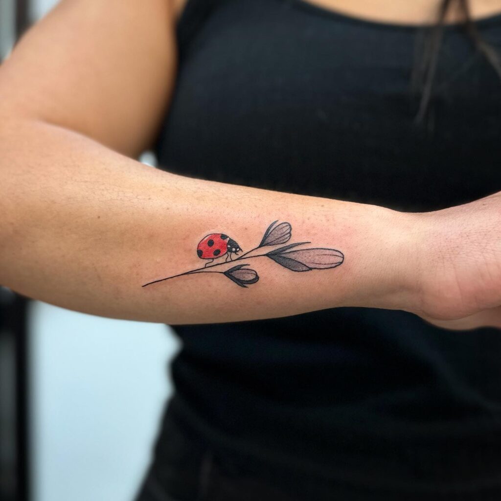 Outer arm Ladybug on Flowers Tattoo: Feminine Floral Ink