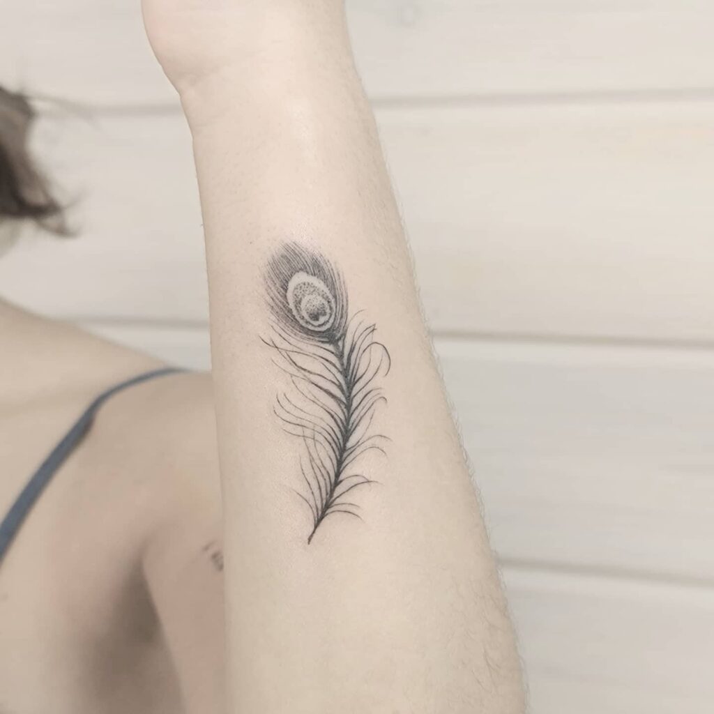 Outer black color wrist peacock feather tattoo bold and beautiful