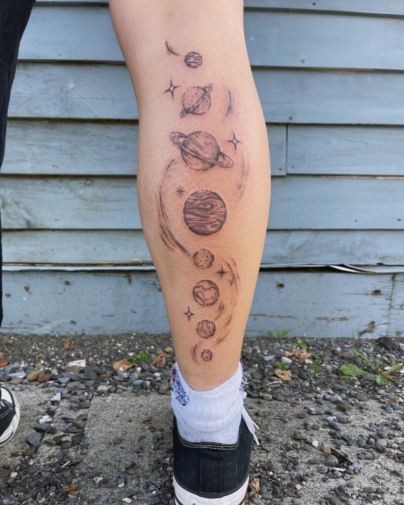 Outer space and solar system calf tattoo depicting the cosmos 