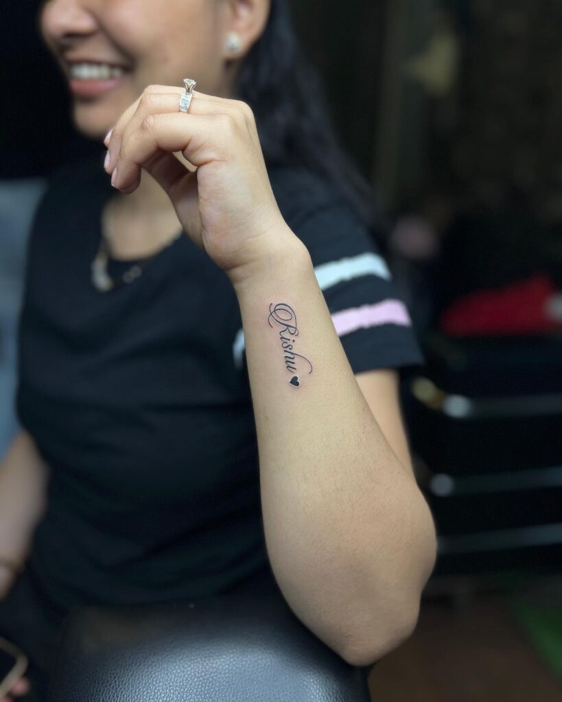Outer wrist rishu name letter with filled black love heart girl