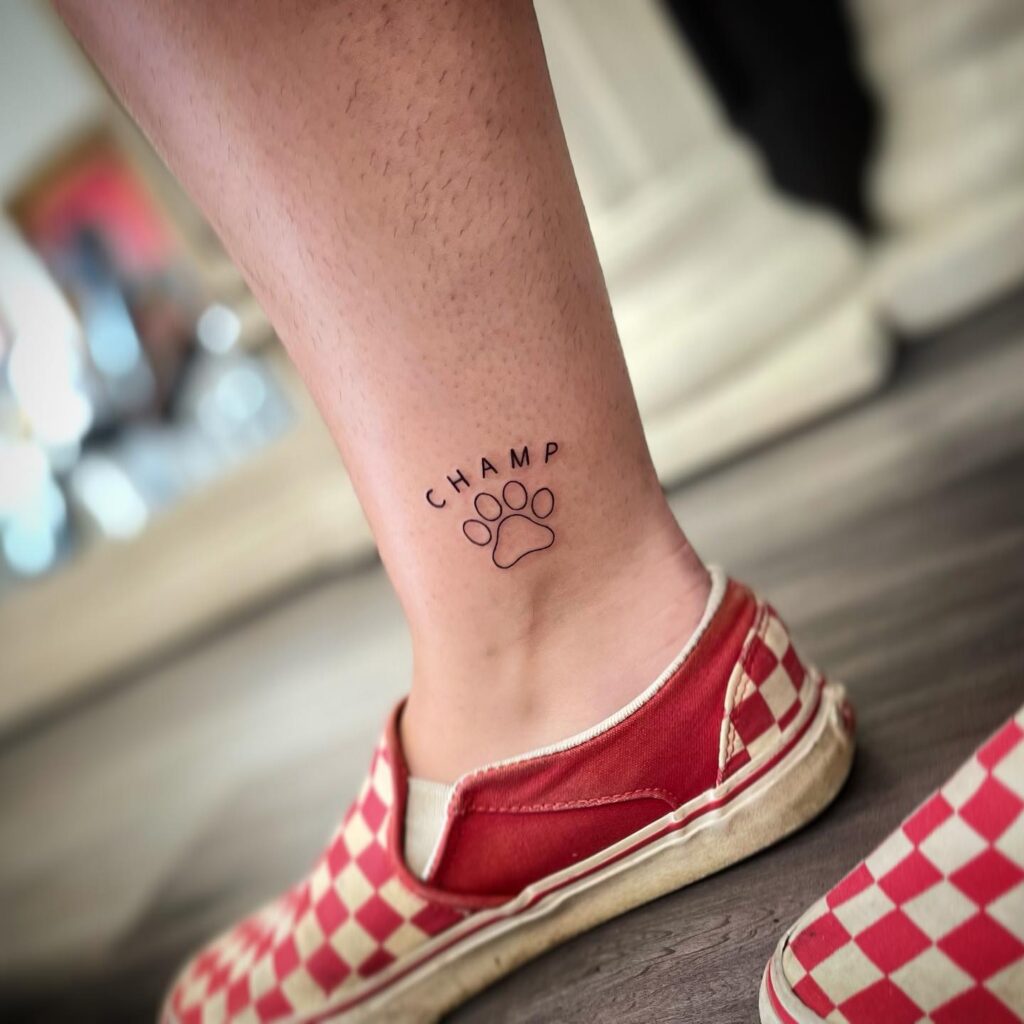 Outline Dog Paw with 'CHAMP' Lettering Above the Ankle: Champion's Tribute