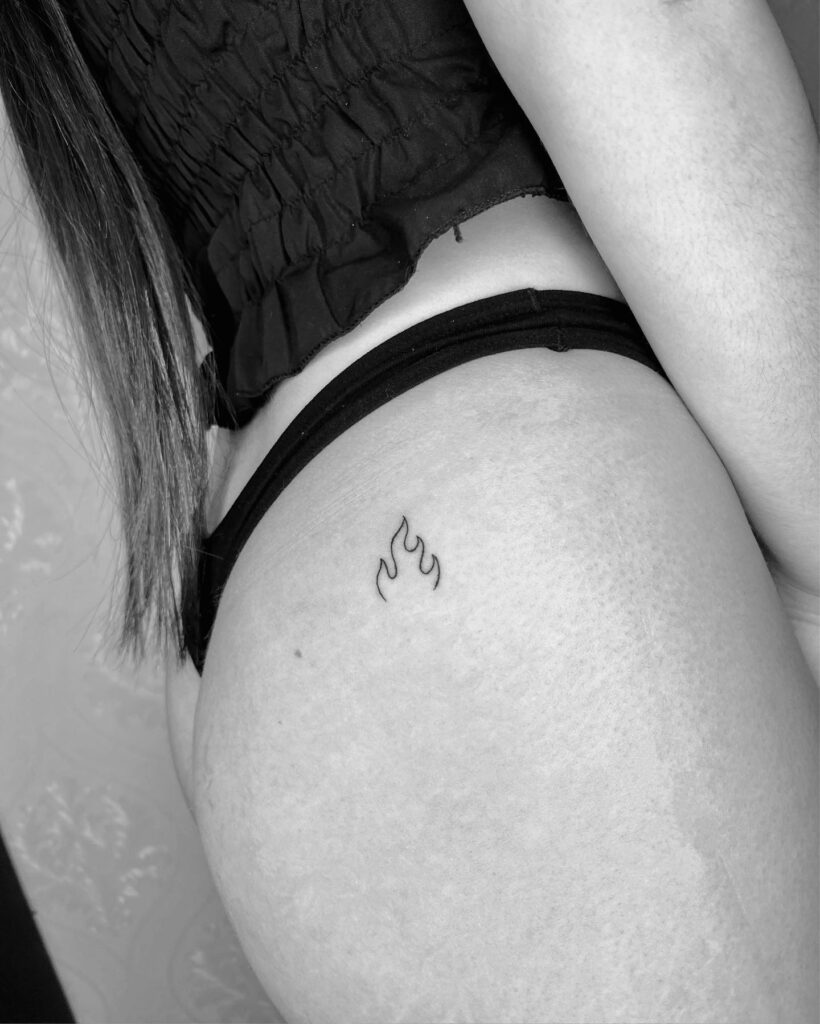 Outline fire symbol tattoo on the buttock, stunning with thin black ink lines: ignite passion