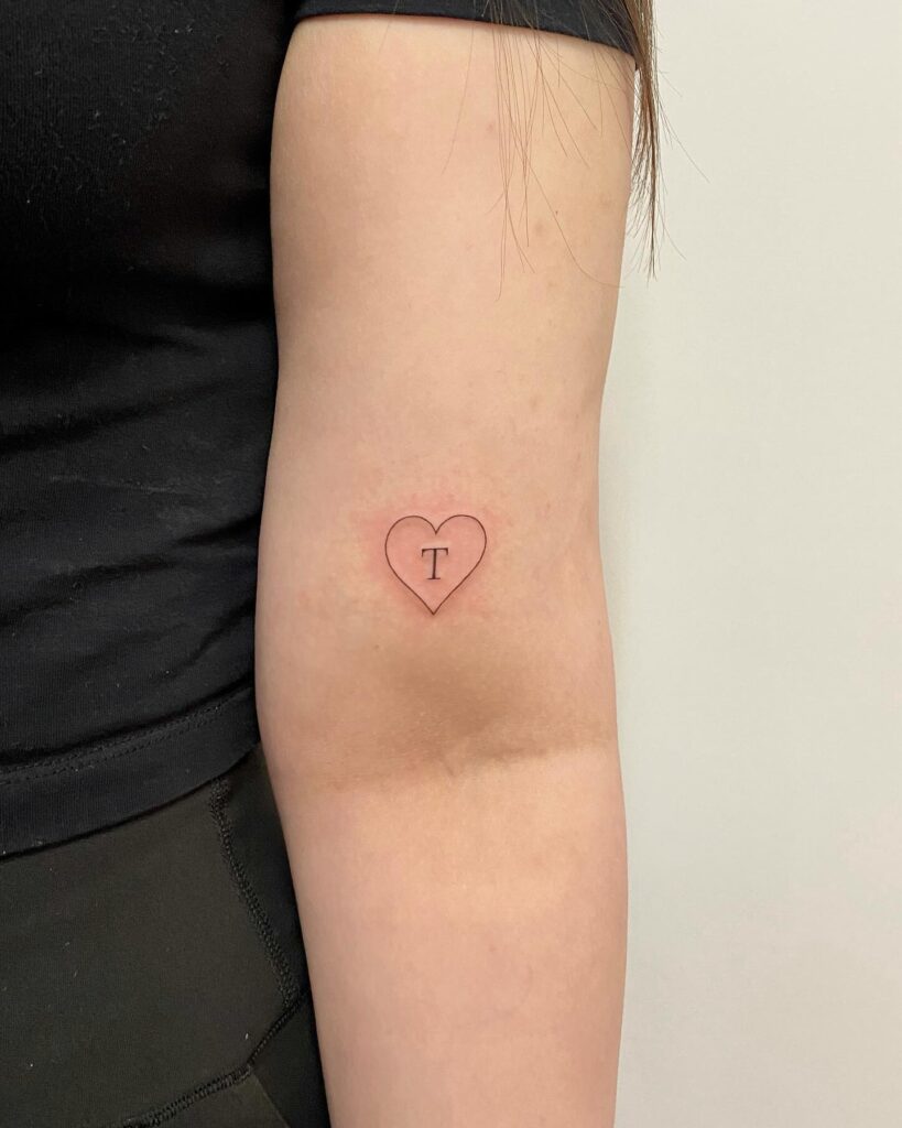 Outline Heart Tattoo Above Elbow with Letter 'T': Heartfelt Tribute