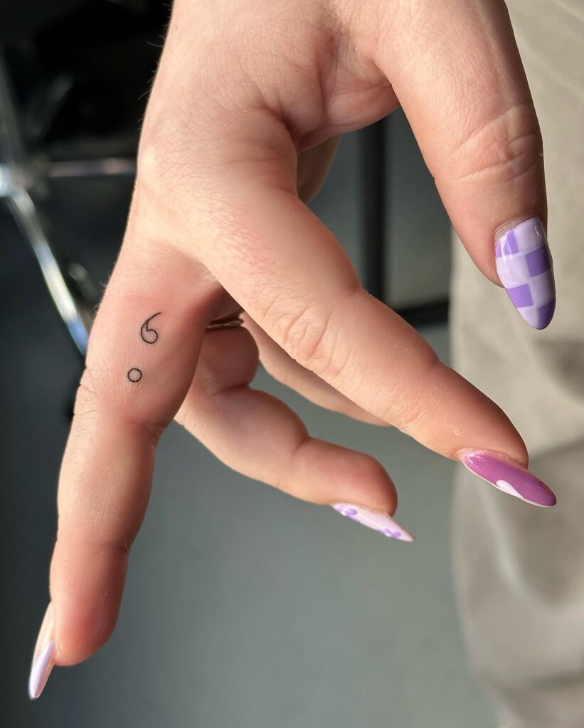 Outline Semicolon Tattoo on the Side of the Middle Finger: Fingerline Pause