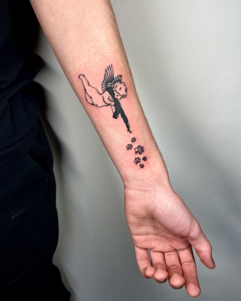 Paw steps with angel with gun tattoo inner forearm a unique statement in body art
