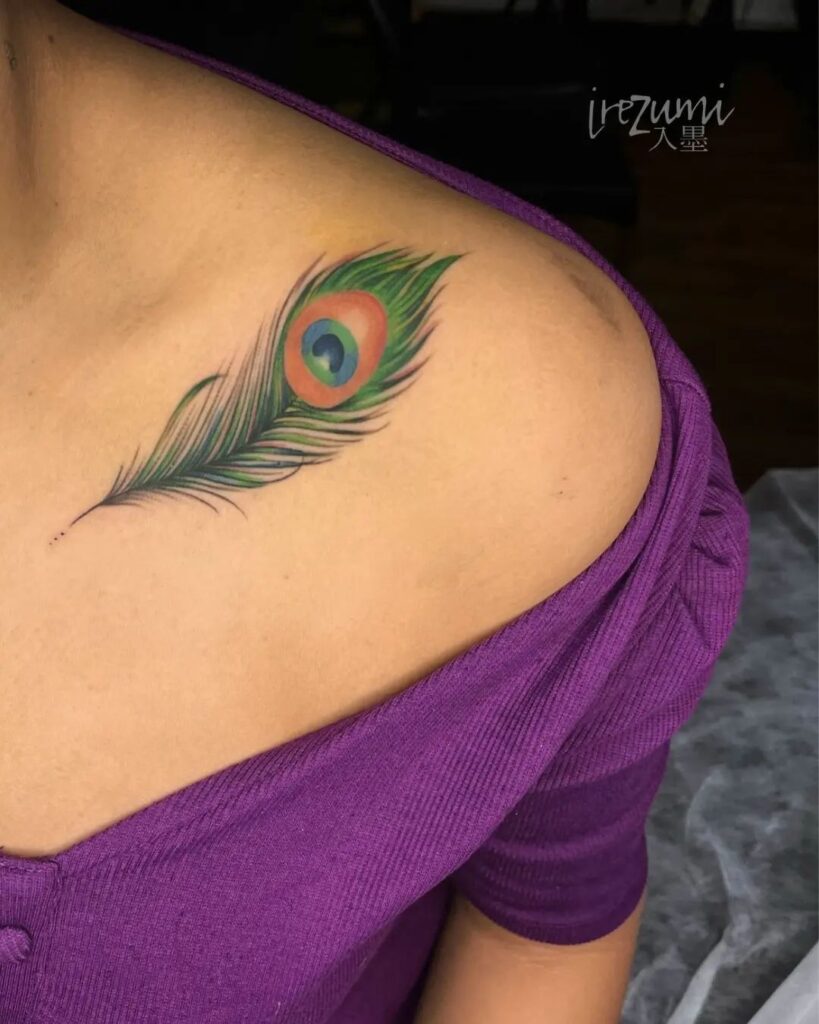 Peacock feather collarbone tattoo, a beautiful burst of colors for women colorful plumage