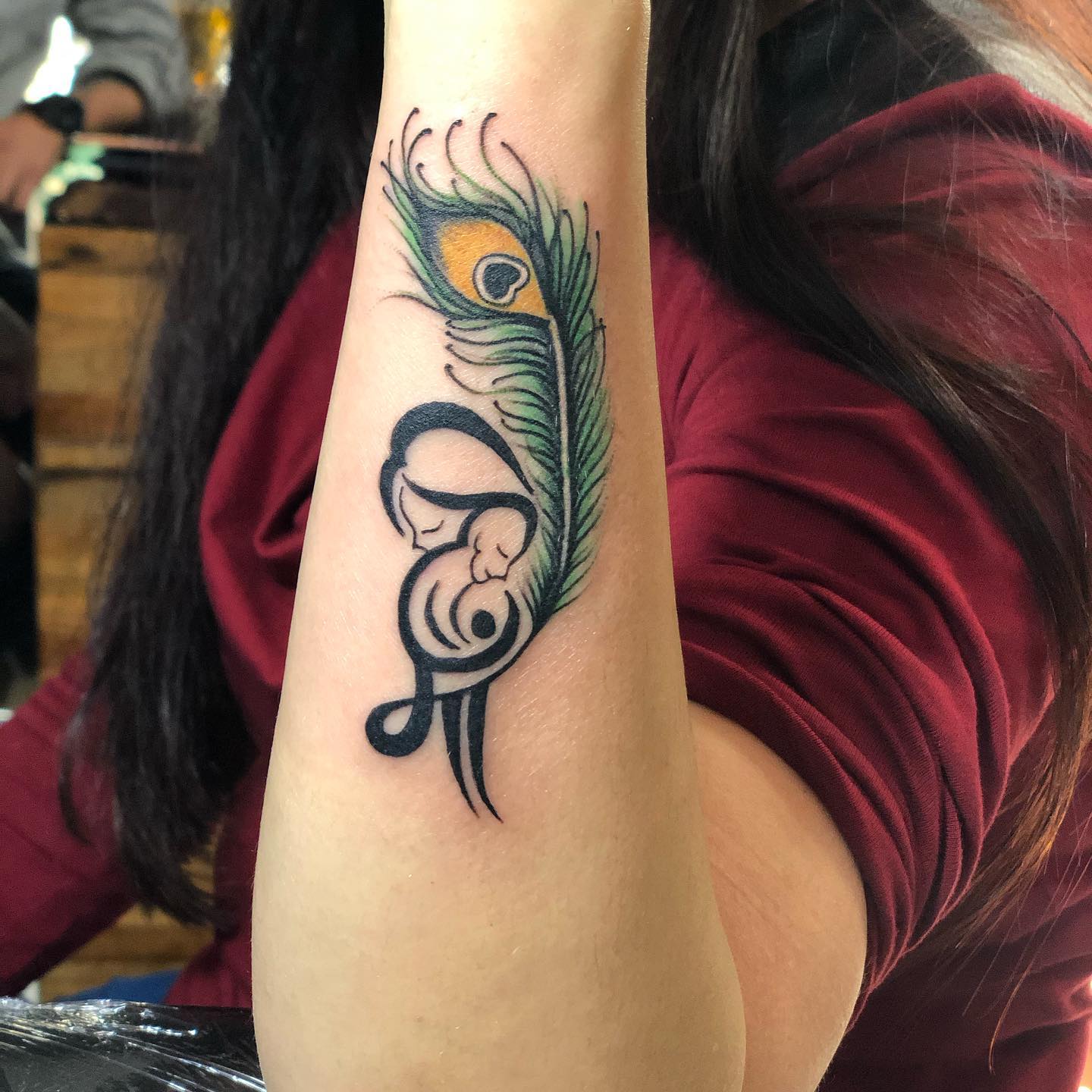 Peacock feather tattoo design on hand with human figure Peacock feather tattoo design on hand with human figure