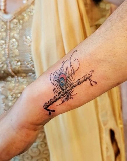 Peacock feather tattoo on hand with flute for women Peacock feather tattoo on hand with flute for women