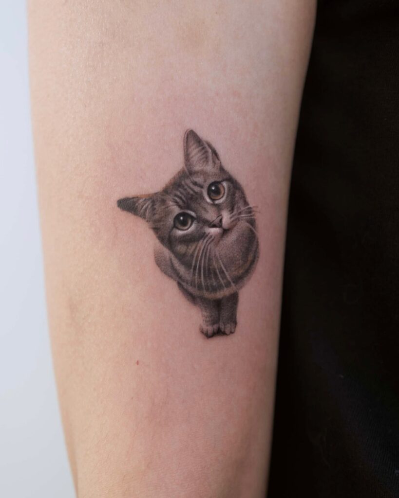 Photorealistic cat tattoo with tilted head and soft shaded fur