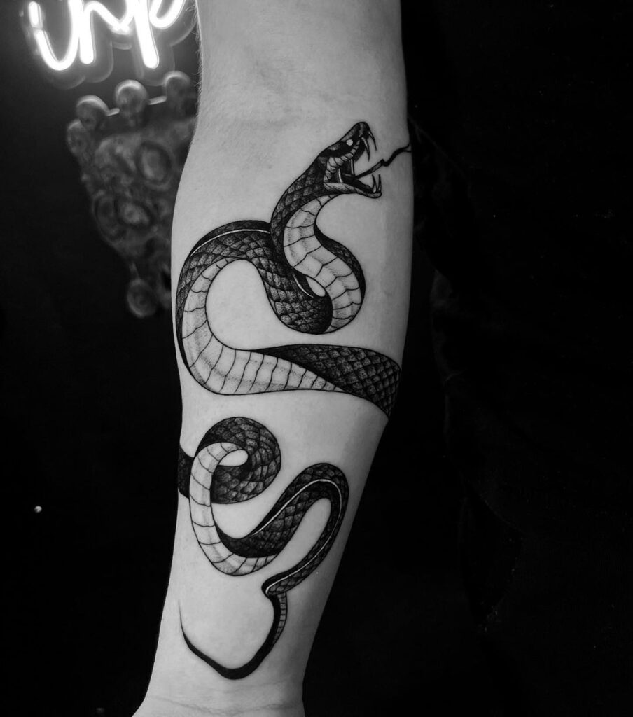 Pissed off cobra tattoo on the forearm bold blackwork design