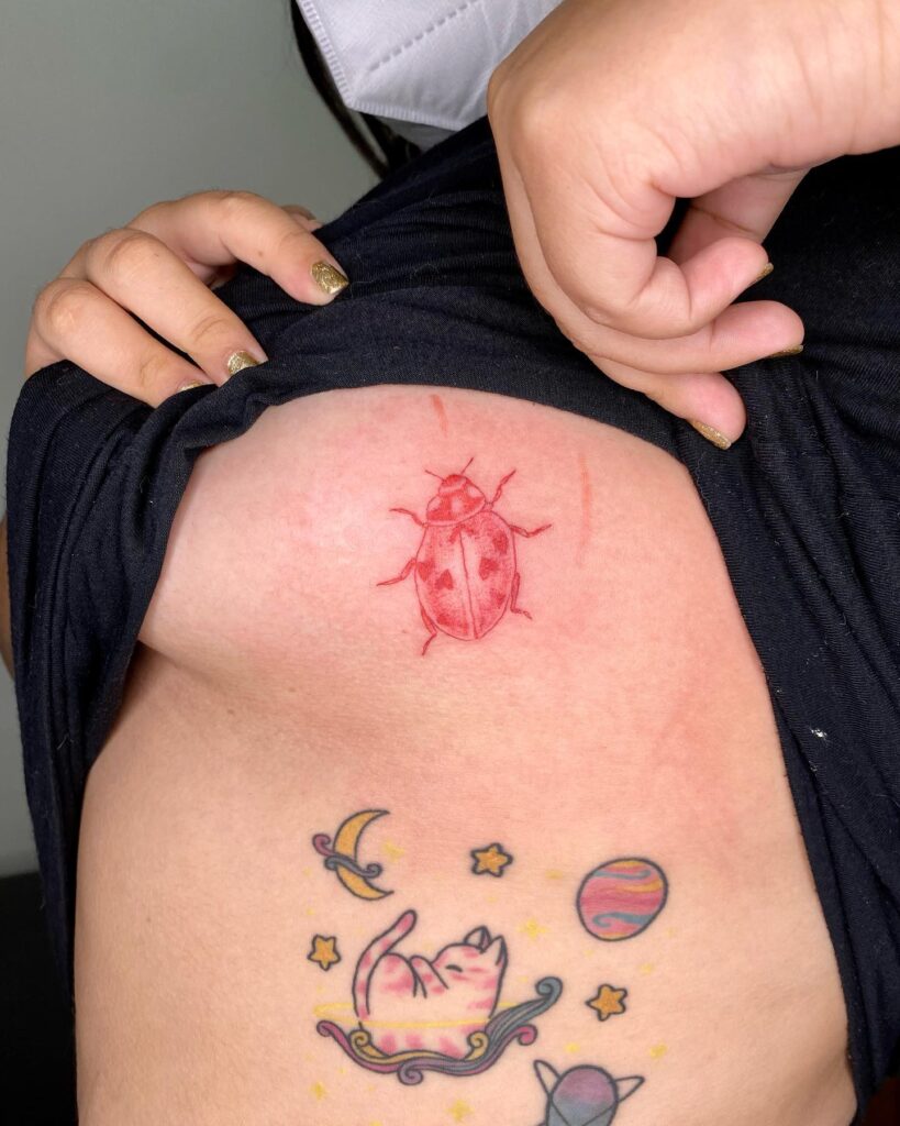 Playful ink red color ladybug tiny side boob tattoo ideas for females