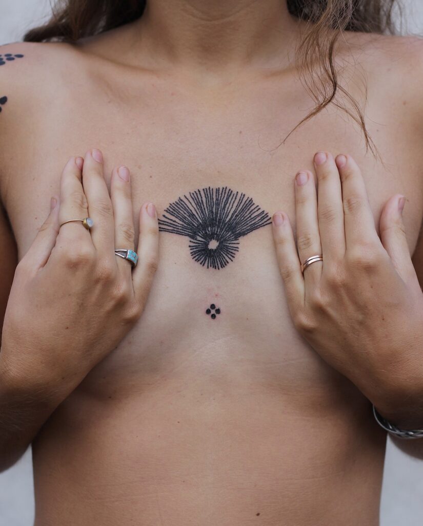 Radiating eye sternum tattoo symbolizing intuition and perception