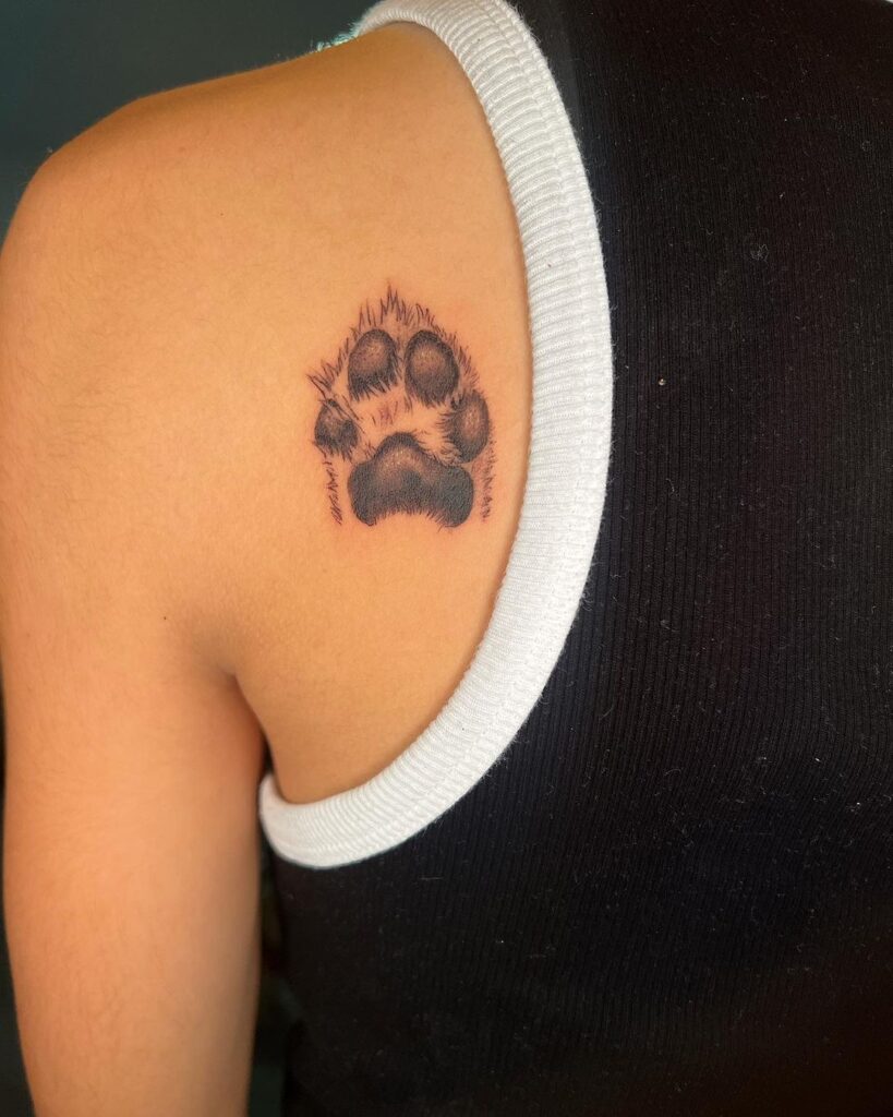 Realism in ink detailed dog paw behind the shoulder tattoo