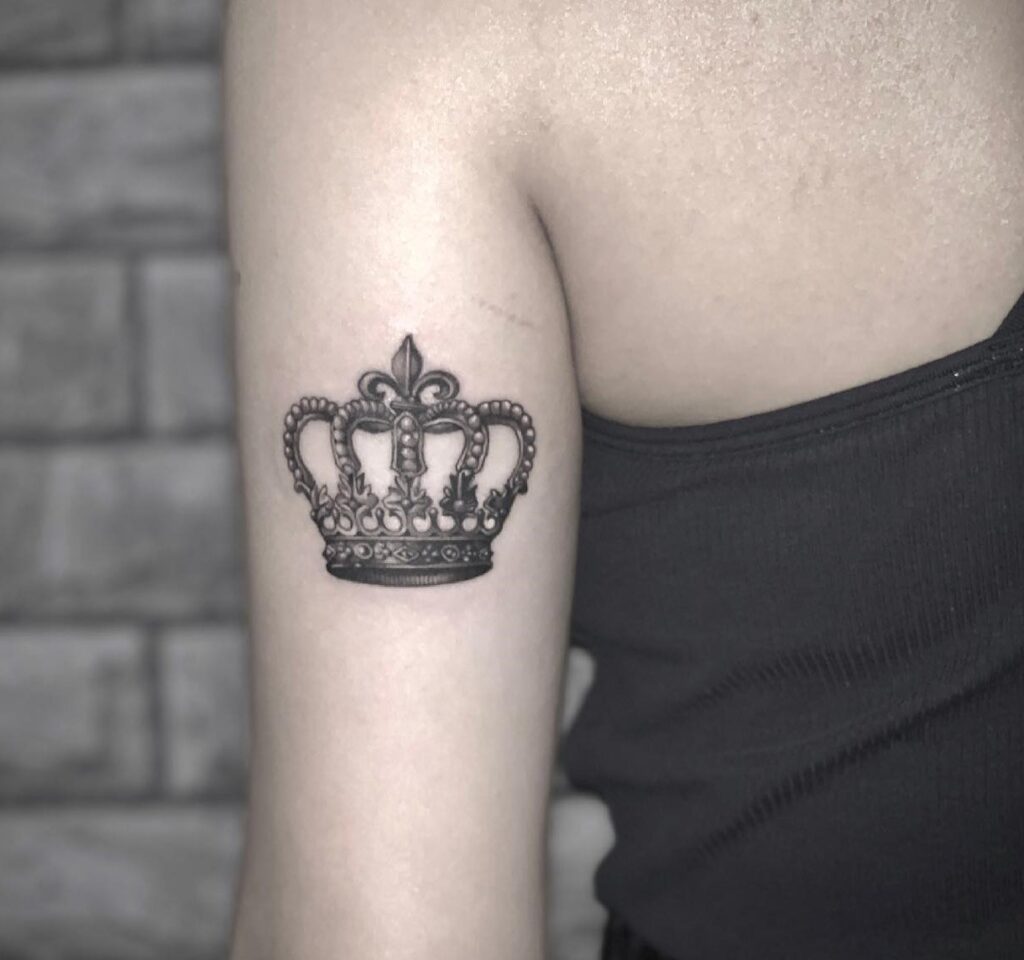 Realistic and Detailed Crown Tattoo for Females, Gracing the Back of the Arm: Royal Emblem