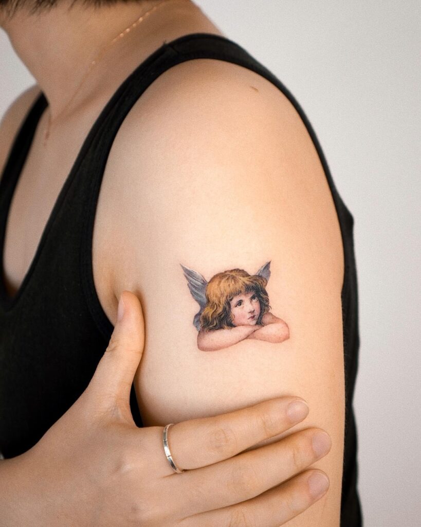 Realistic Baby Angel Tattoo on the Shoulder: Colorful Serenity