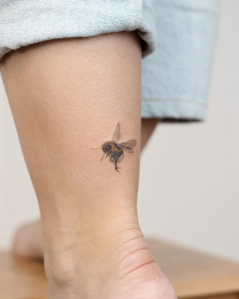 Realistic Bee Tattoo Near the Ankle and Back of the Leg, a Colorful Side View: Buzzy Beauty