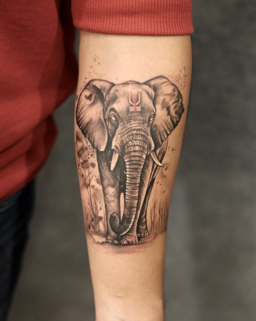 Realistic black and gray elephant tattoo on forearm, detailed and bold, featuring an indian elephant with a tilak mark, front view bold elegance