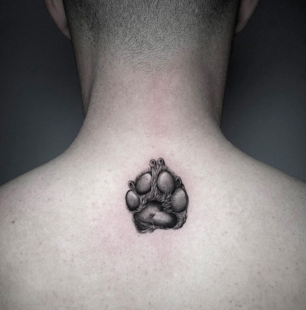 Realistic Black and Grey Dog Paw Tattoo at the Back of the Neck for Men: Nape's Elegance