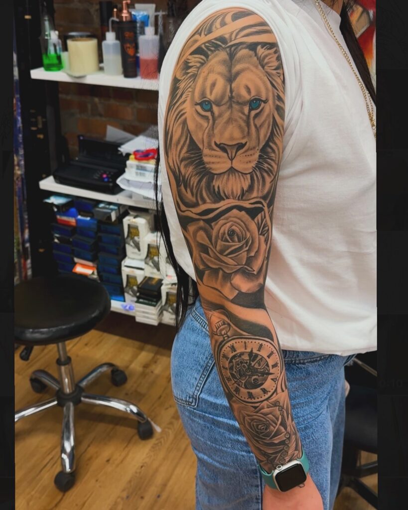 Realistic black and grey lion tattoo sleeve with blue eyes and roses